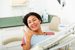 Female dental patient giving a thumbs up