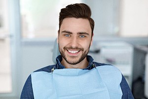 Male periodontal patient with beard sitting and smiling 